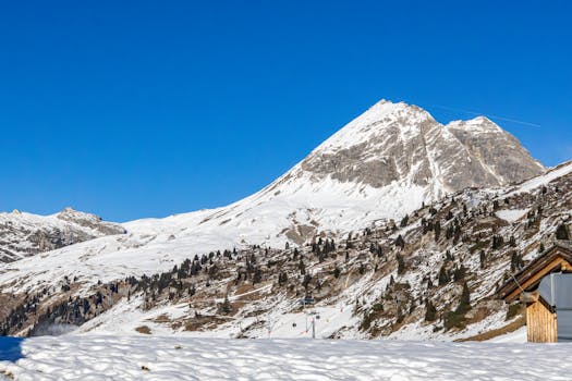 Explore the serene beauty of the snow-covered Austrian Alps under a clear blue sky.
