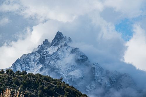 Free Stunning view of snow-capped mountain peaks shrouded in clouds, creating a dramatic and mystical atmosphere. Stock Photo