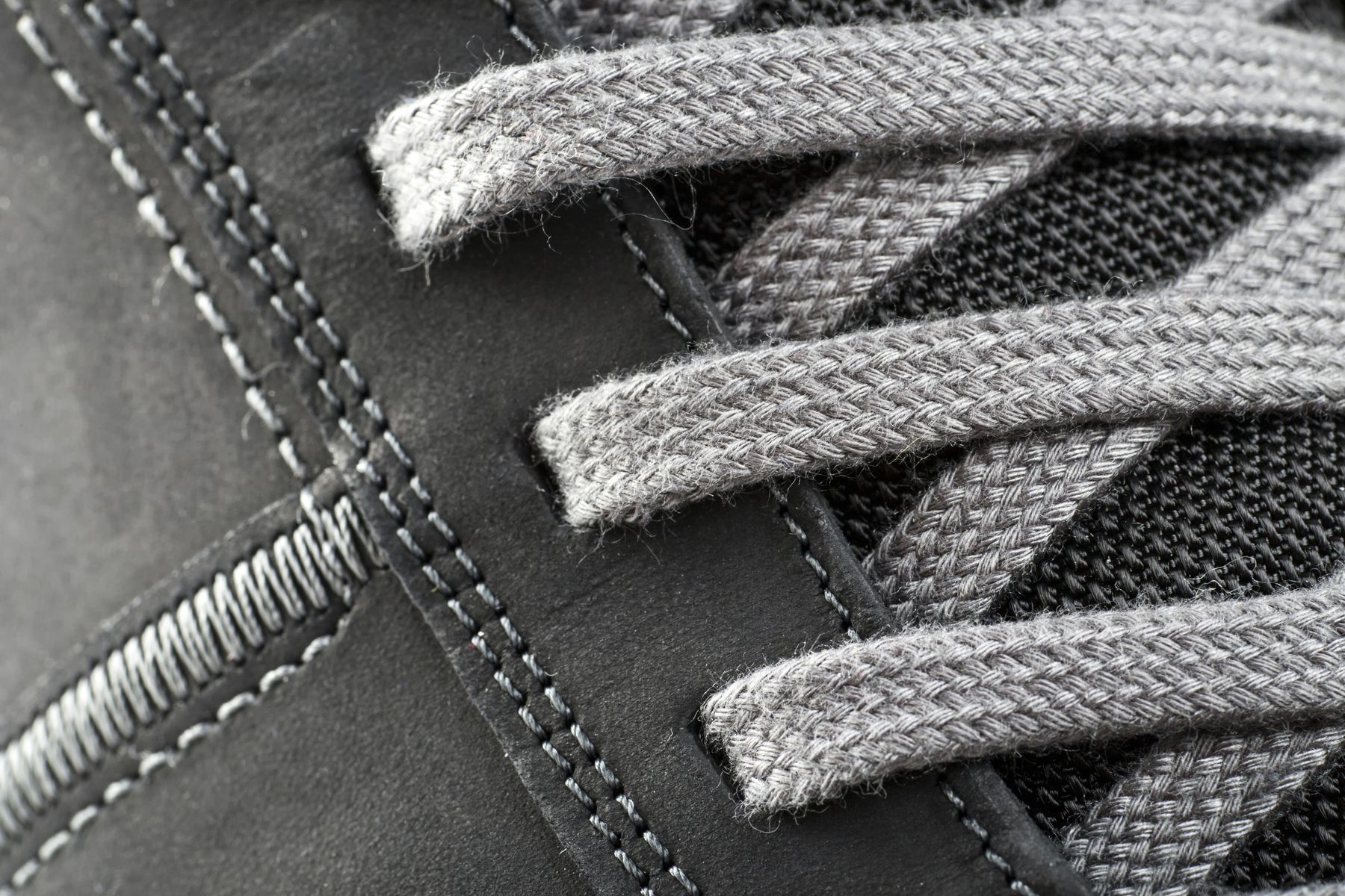 Close-up of sneaker laces and stitched technical panels