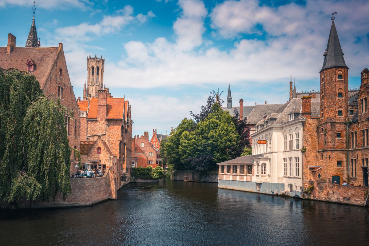 Bruges canal and medieval architecture under bright sky