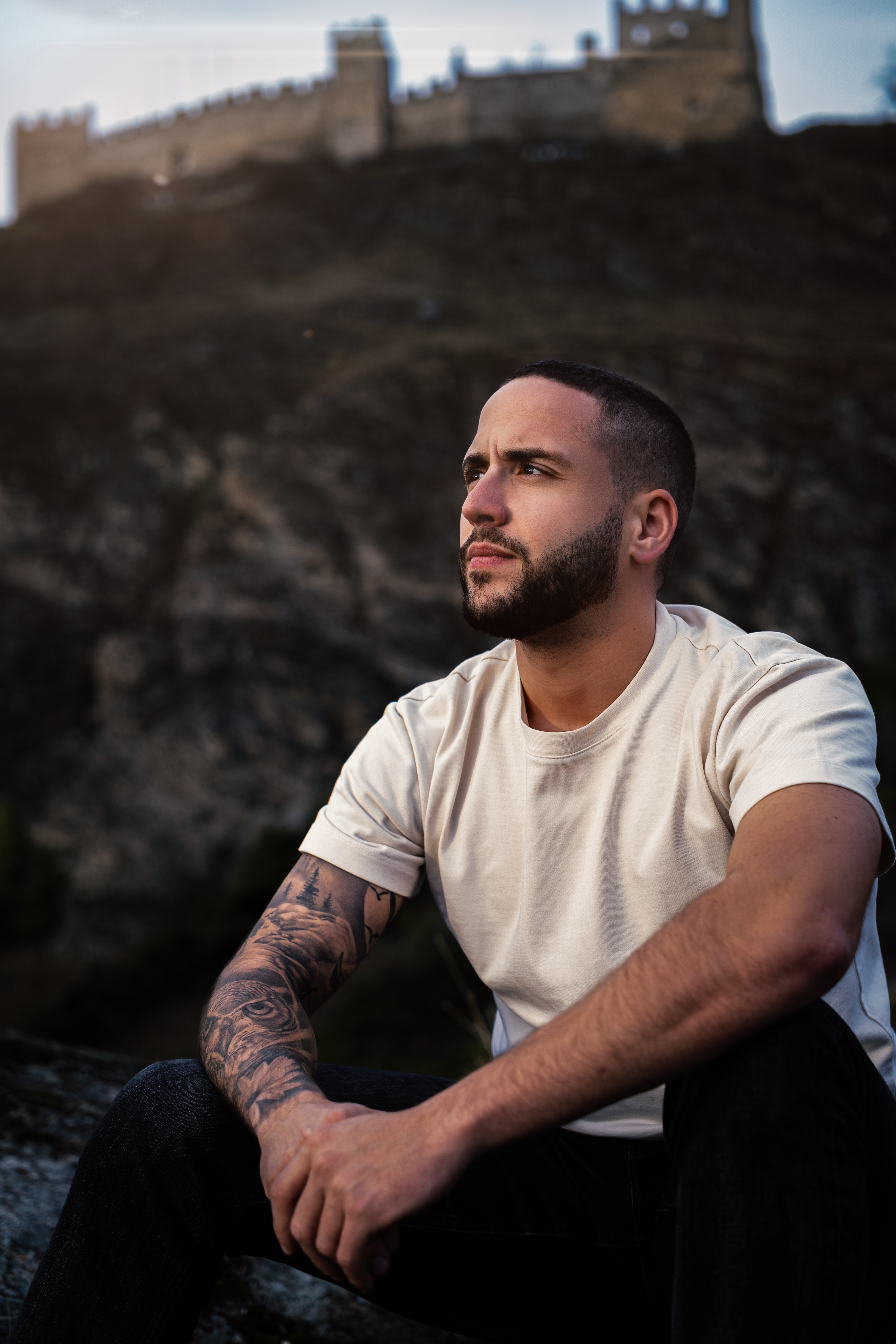 Man Sitting Outdoors with View of Sion Castle · Free Stock Photo