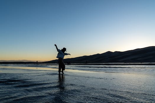 A cowboy silhouetted against the dusk at the stunning Colorado sand dunes, capturing an adventurous spirit.