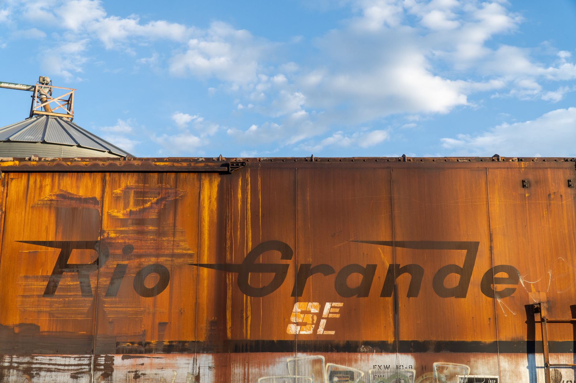 Rusty Rio Grande boxcar against a blue sky in Strasburg, Colorado.