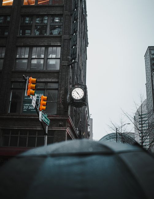 View of a clock tower and traffic lights in downtown Indianapolis with a moody sky.
