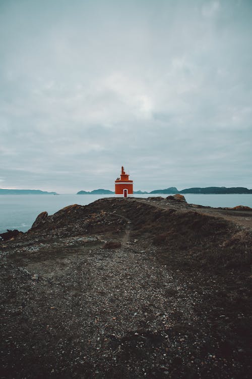 多云的天空下海附近的灯塔