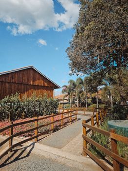 Beautiful countryside scene with a rustic barn, path, and trees under a clear blue sky.