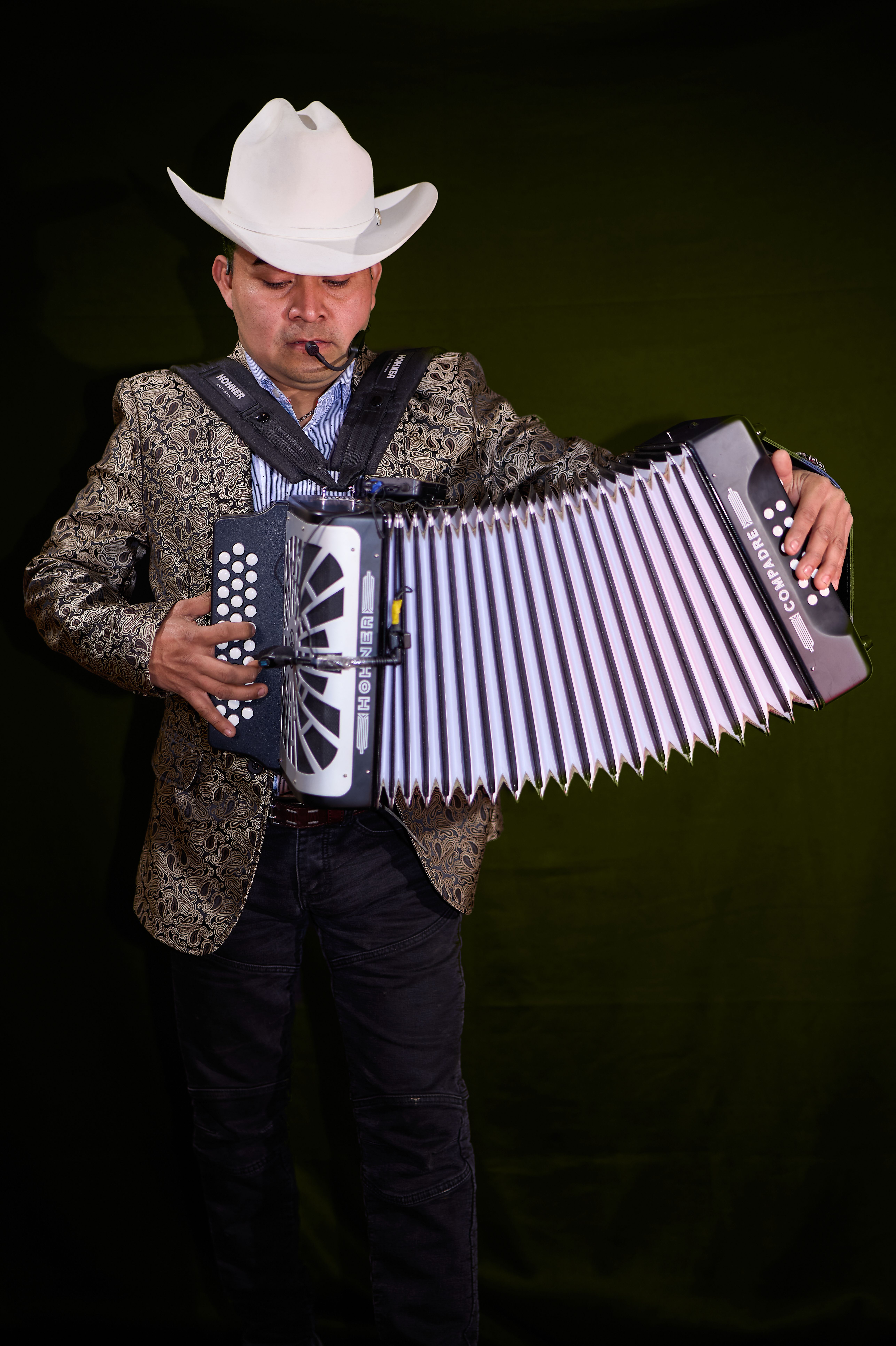 Portrait of a man in a cowboy hat playing an accordion with focus and passion.