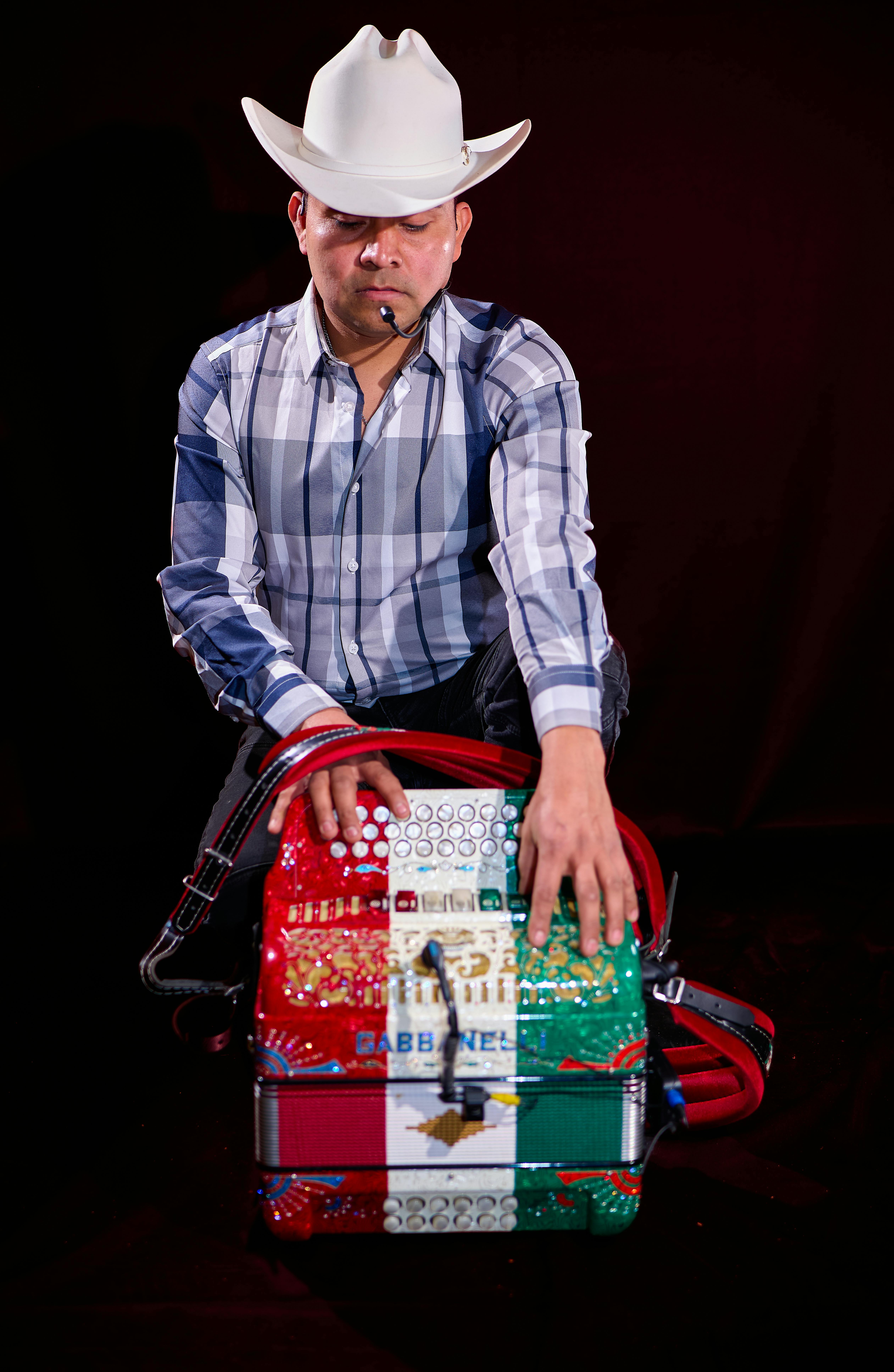 Man wearing cowboy hat with colorful accordion on stage