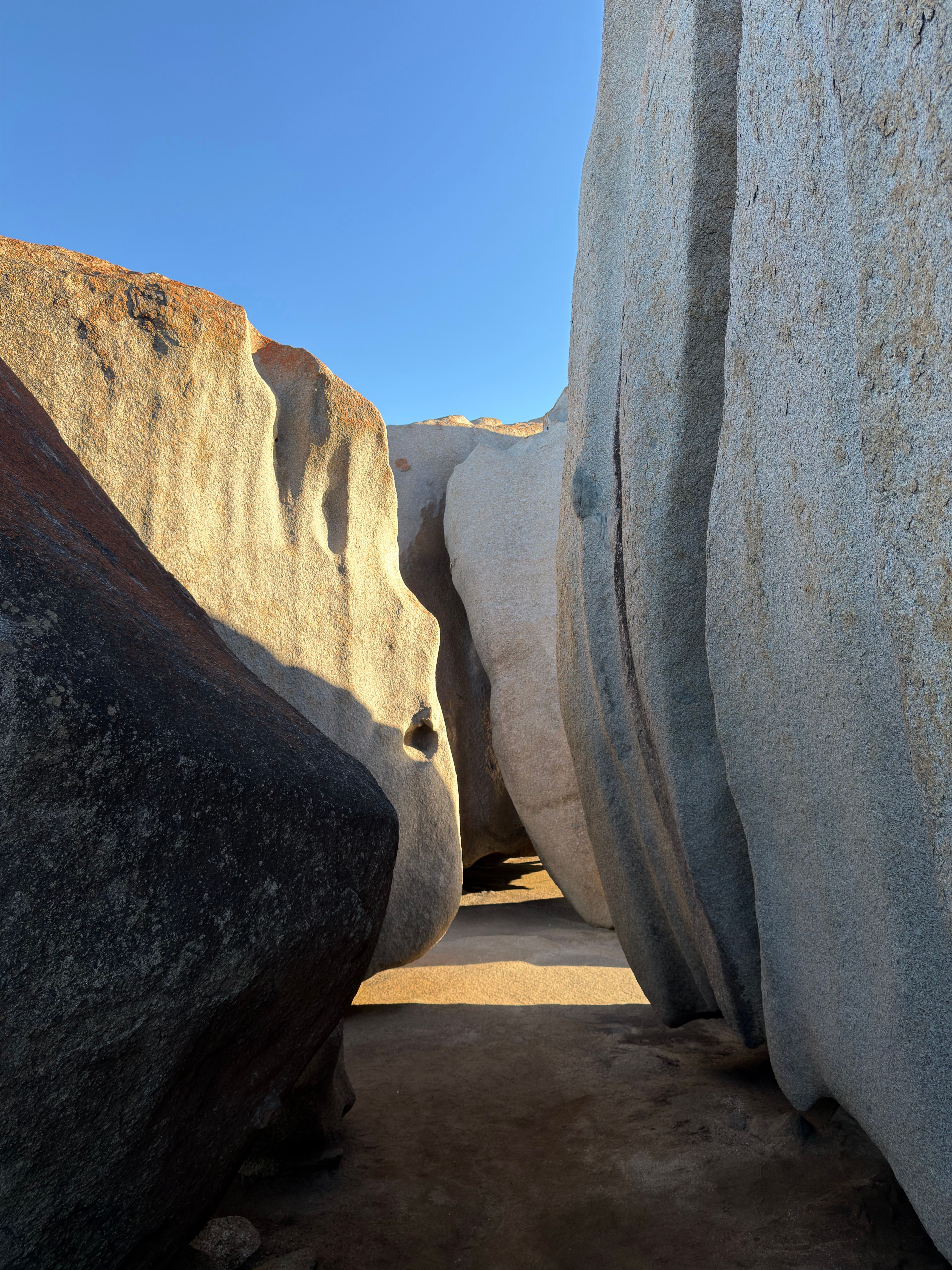 Dramatic rock formations in a natural setting under a clear blue sky, showcasing geological beauty.
