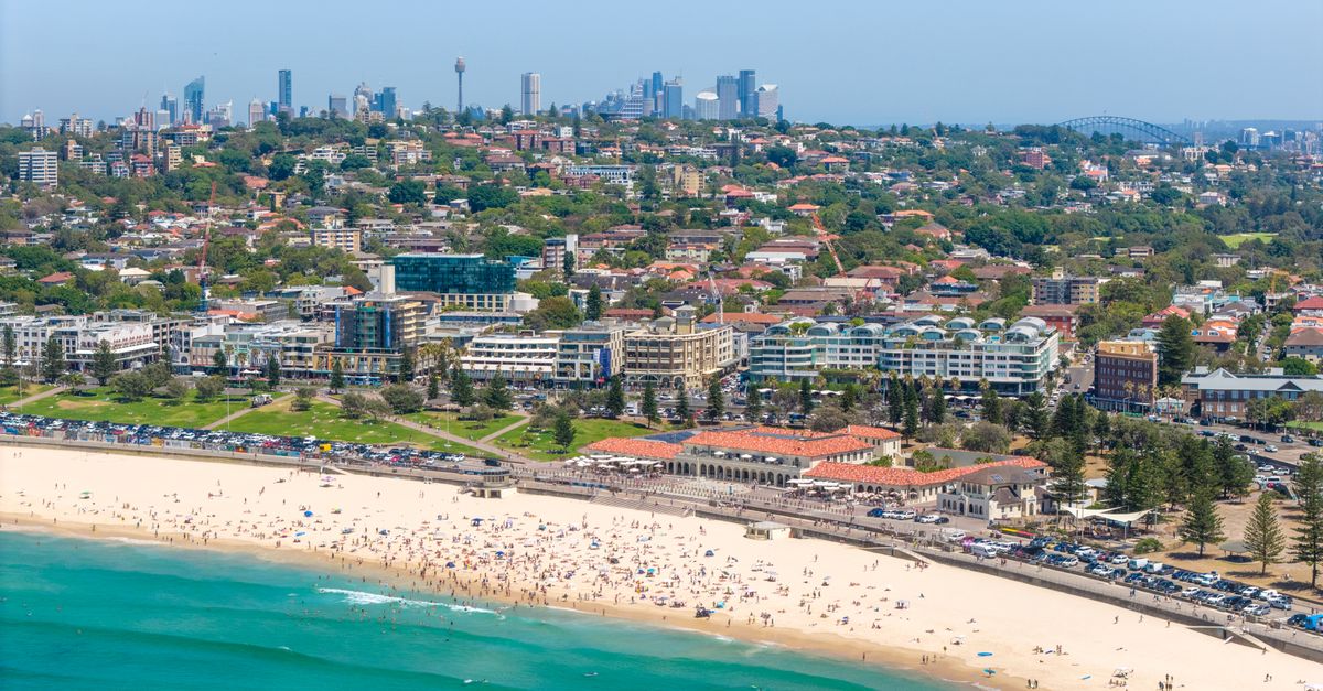 Explore Bondi Beach in Sydney with bustling sands and city skyline views on a sunny day.