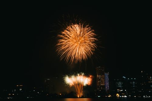 Free Spectacular fireworks illuminating the night sky above a city skyline. Stock Photo