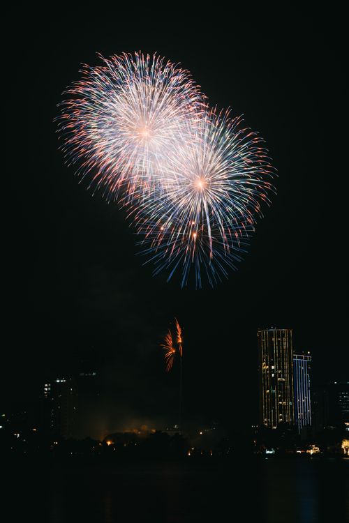 Free A stunning display of colorful fireworks illuminating the city skyline on a clear night. Stock Photo