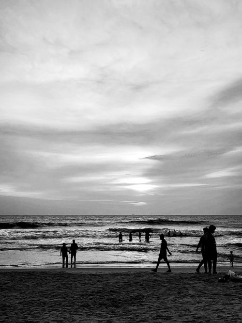 Free Silhouetted people enjoy a serene sunset at Varkala Beach, Kerala, embracing nature's beauty. Stock Photo