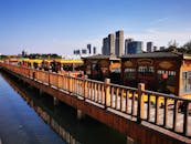 Scenic Waterfront with Traditional Boats and Modern Skyline