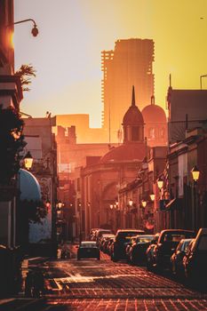 Captivating golden sunset illuminating a historic street in Santiago de Querétaro, Mexico.