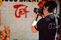 Photographer in action with a DSLR camera, emphasizing creativity and focus.