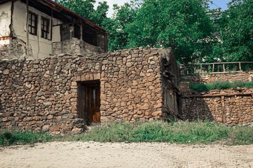 Free Explore the charm of a vintage stone house with rustic architecture in a natural setting. Stock Photo