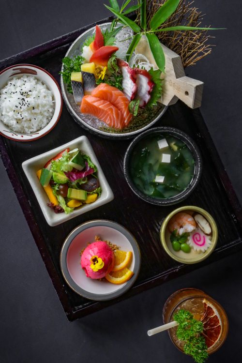Free A beautifully presented Japanese meal featuring sashimi, rice, and side dishes in a traditional setup. Stock Photo