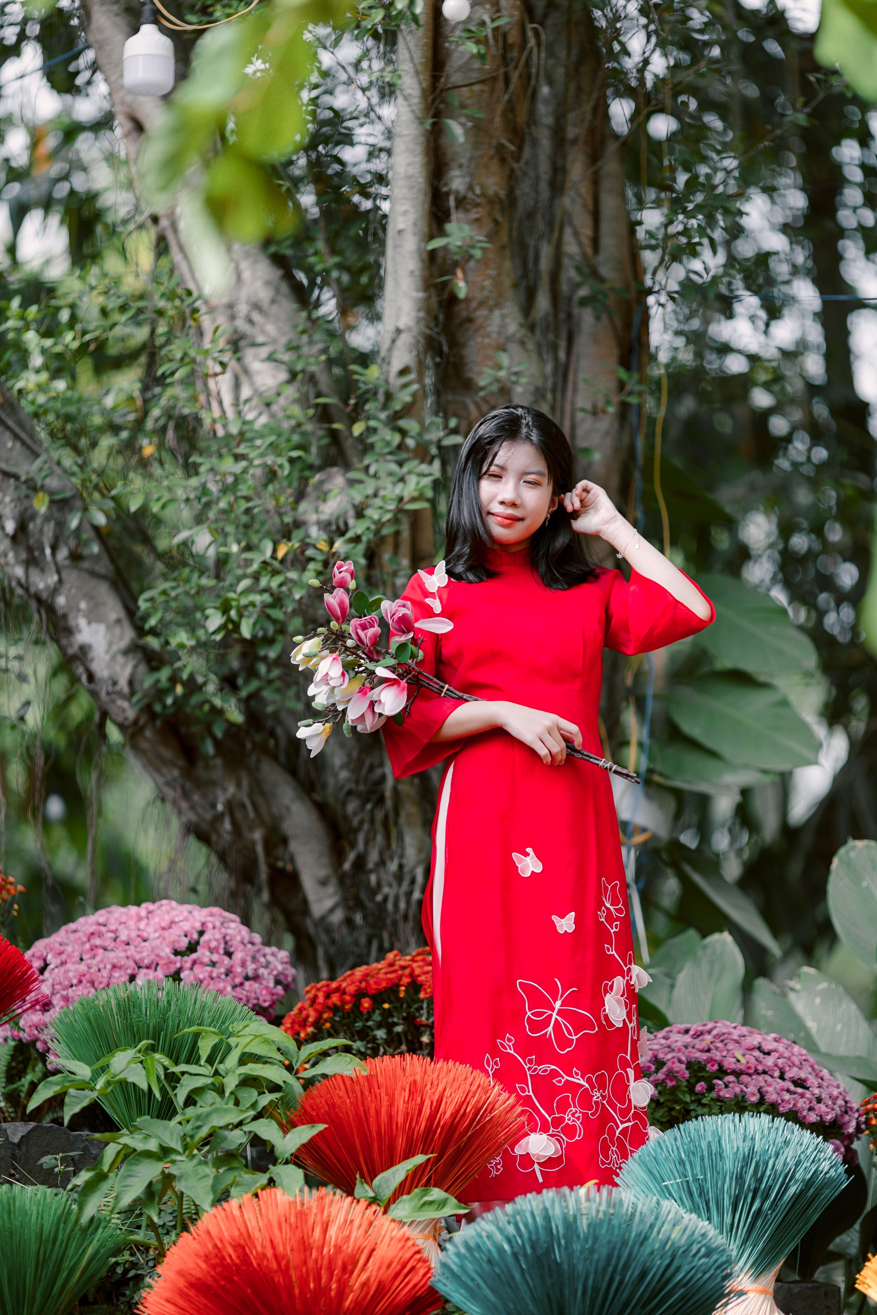 Woman in Red Dress Holding Flowers Outdoors · Free Stock Photo