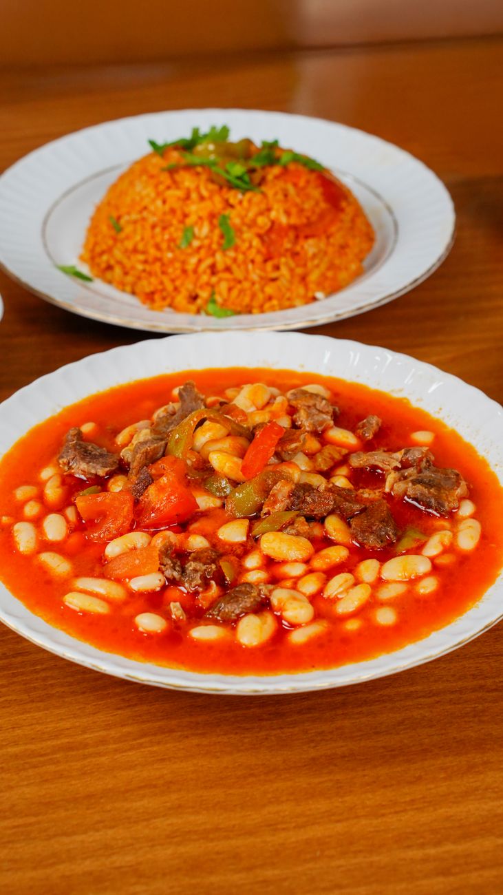 Derin bir kasenin içinde, taze maydanoz yaprakları ile süslenmiş, buharda tüten zengin soslu ve mantarlı Burgonya dana yahni (Boeuf Bourguignon).
