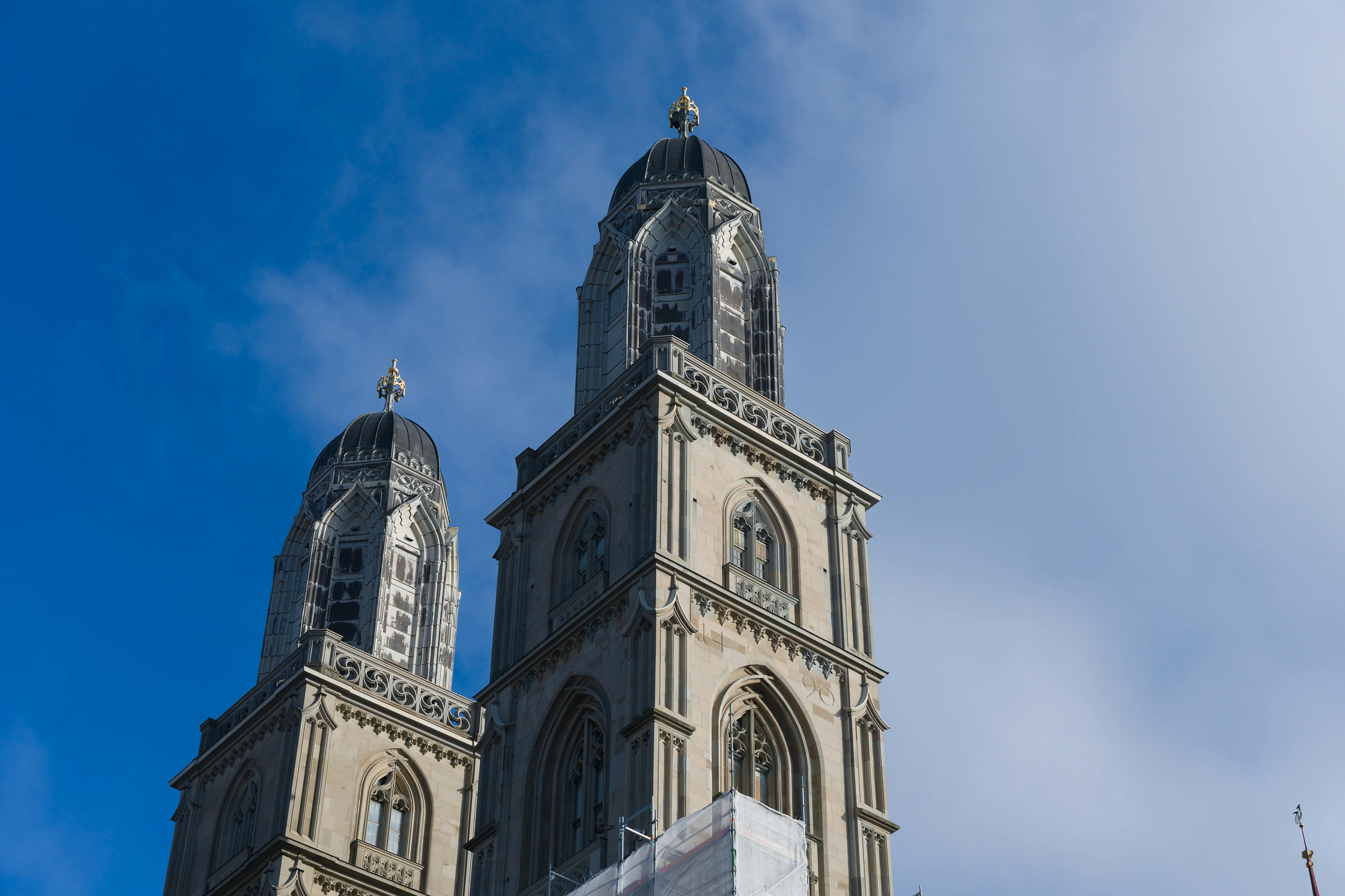 Close-up of the historic Grossmünster twin towers in Zurich under a clear blue sky.