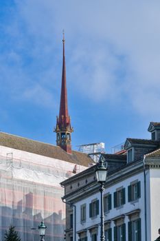 A charming view of Zurich's historic architecture with a church spire against a clear sky.