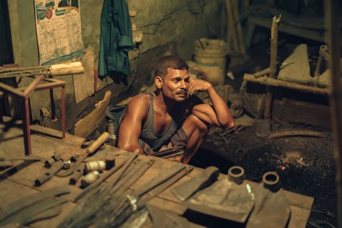 Free A blacksmith resting in his workshop in Bangladesh, surrounded by tools and materials. Stock Photo