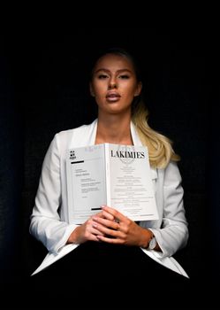 A focused female law student reading a legal journal in a library setting.