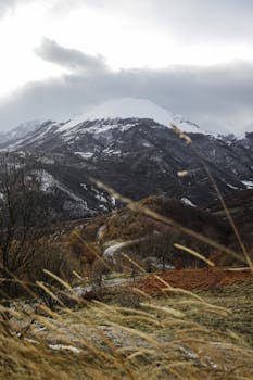 Breathtaking view of snow-capped mountains and winding road during winter.