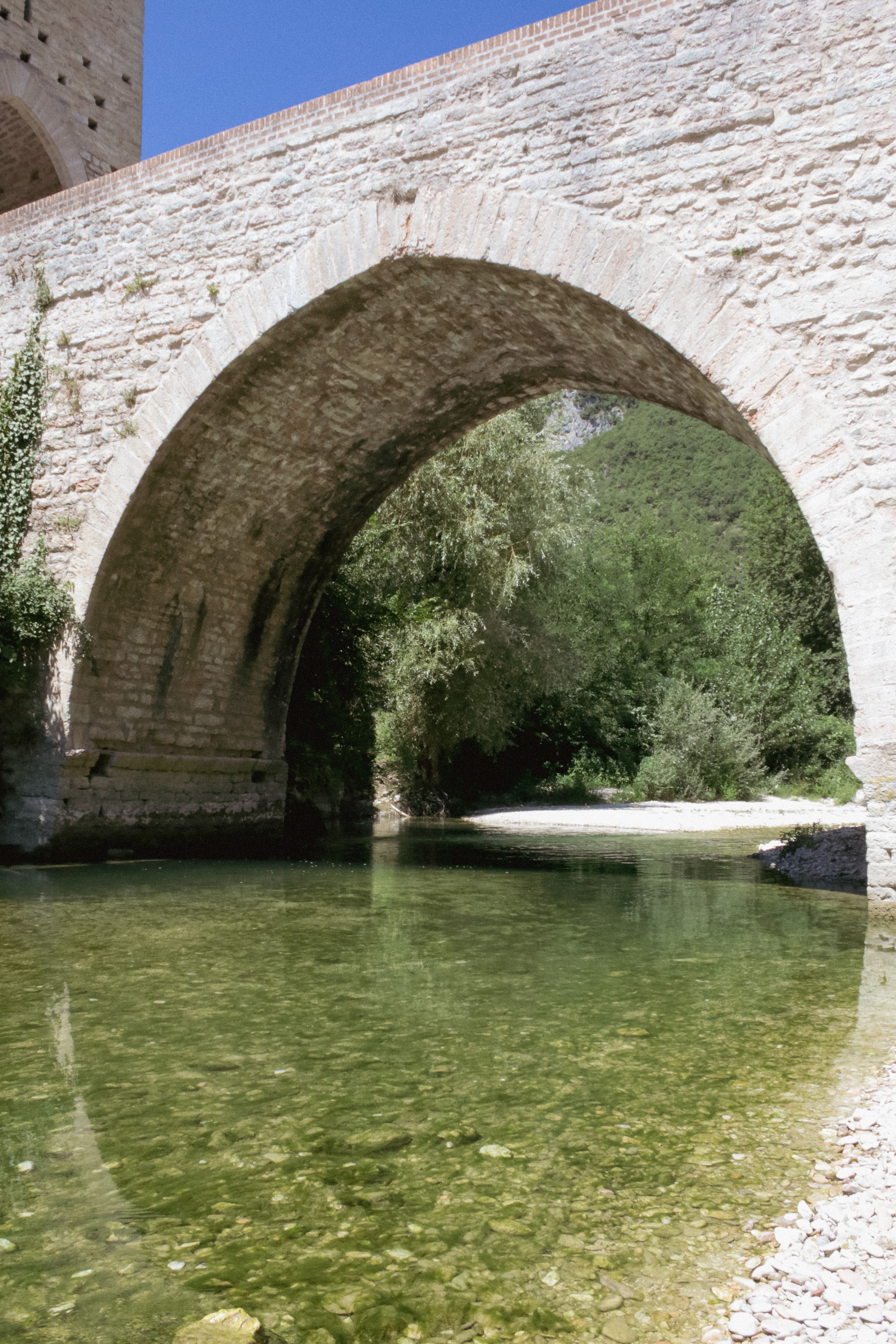 Stone Arch Bridge Over Clear River in Nature · Free Stock Photo