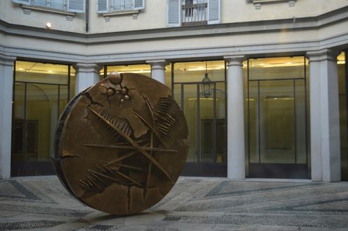 Free A bronze sculpture with abstract design in an urban courtyard setting. Stock Photo