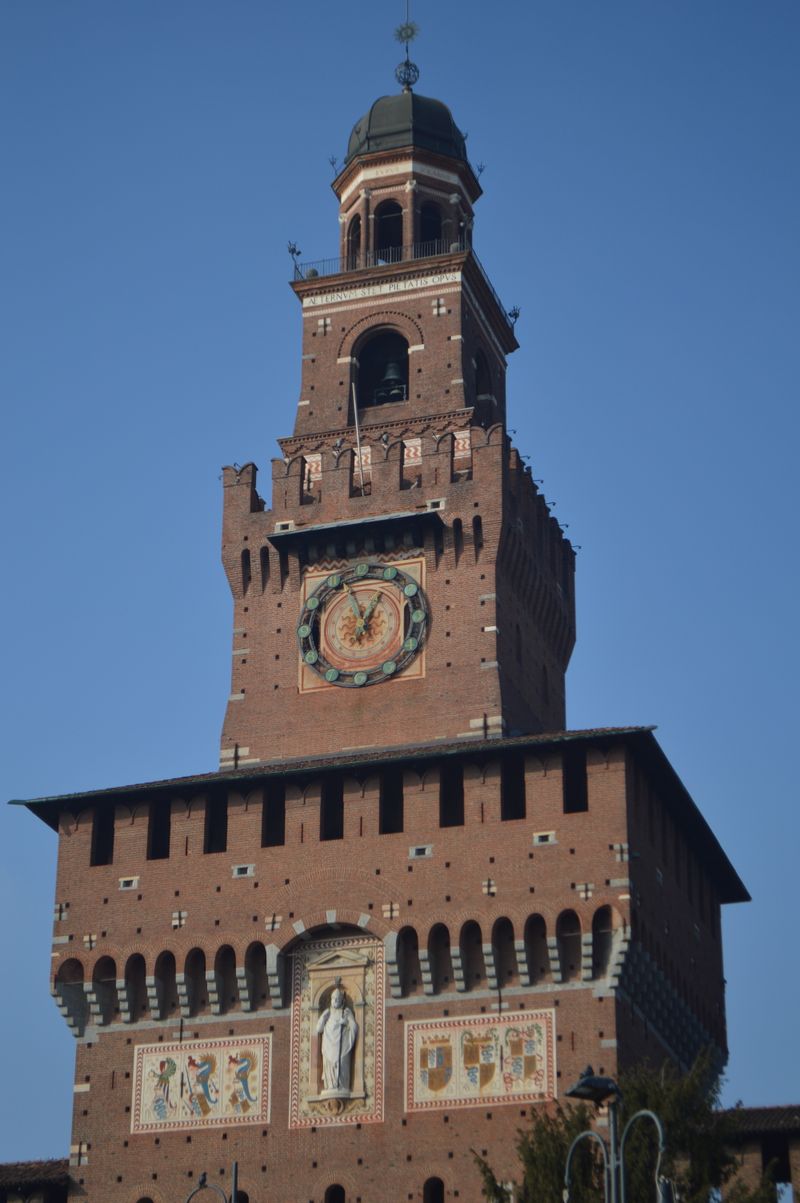 Clock tower of Sforza Castle in Milan against a blue sky