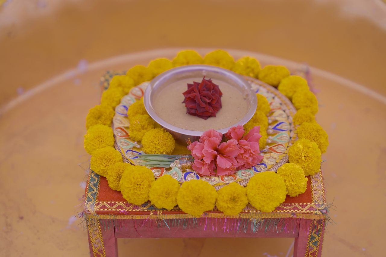vibrant flower arrangement with marigolds and rose petals on a ceremon