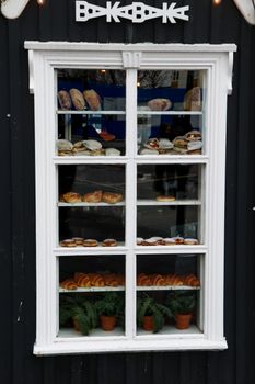 A charming bakery window in Reykjavík showcasing fresh bread and pastries.