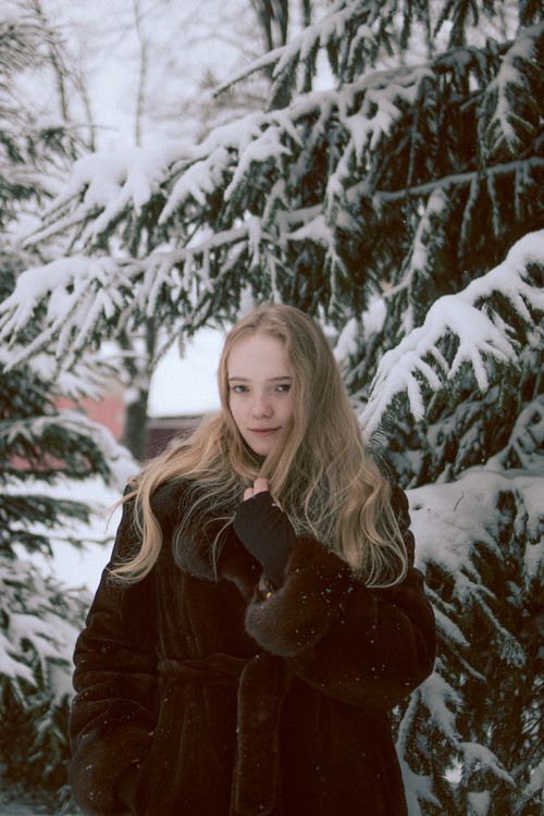 Young woman in a fur coat in a snowy pine forest — Tatyana Doloman on Pexels
