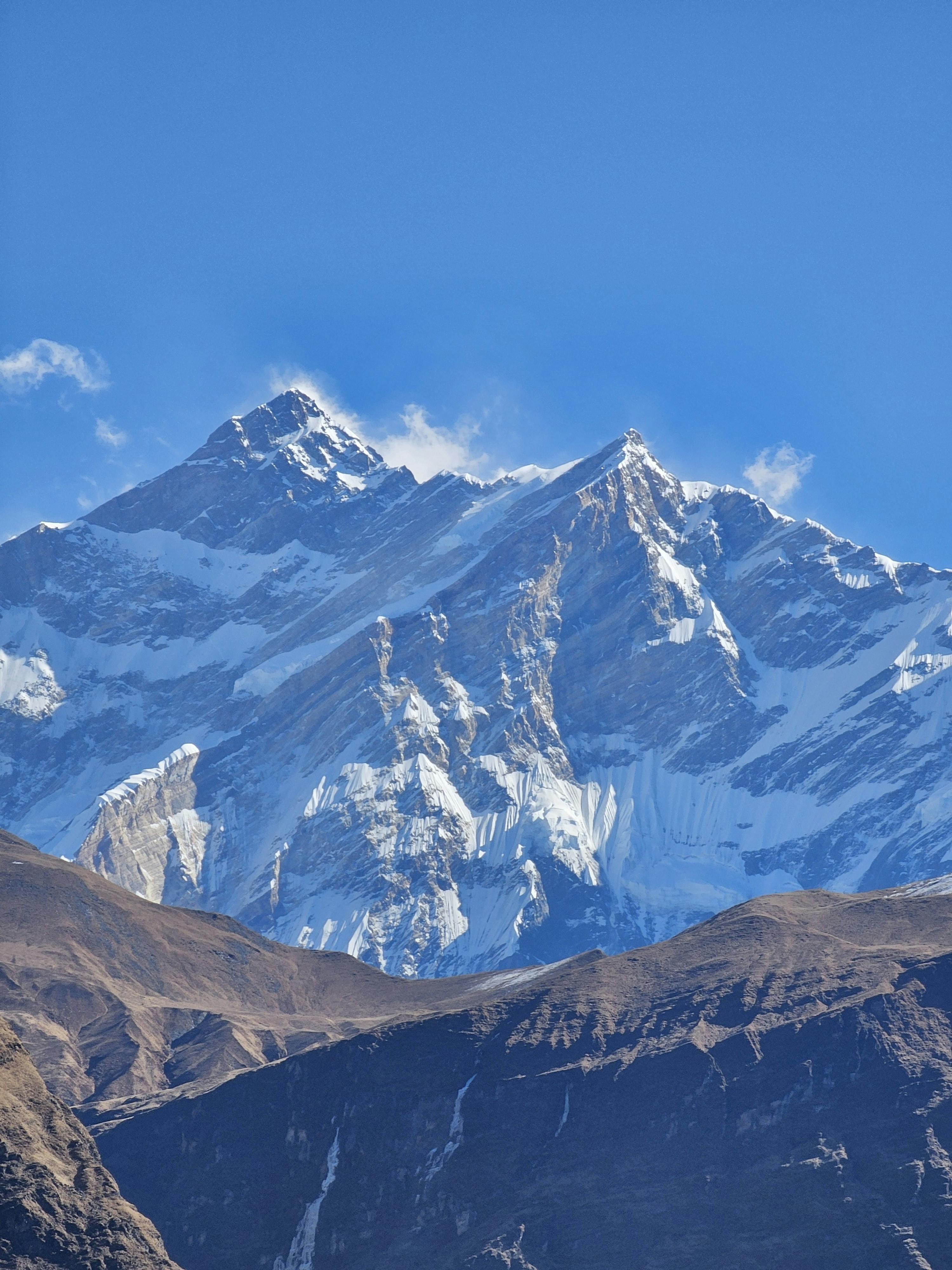 Stunning view of the Himalayas' snowy peaks against a vivid blue sky, perfect for travel and nature themes.