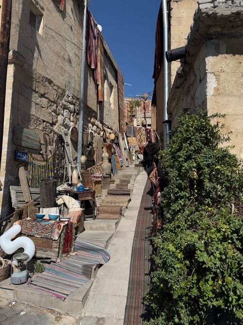 Free Explore a picturesque Turkish alley with traditional market stalls and vibrant textiles in Cappadocia. Stock Photo