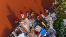 Drone capture of colorful fishing boats moored on the edge of Lac Rose, Senegal.