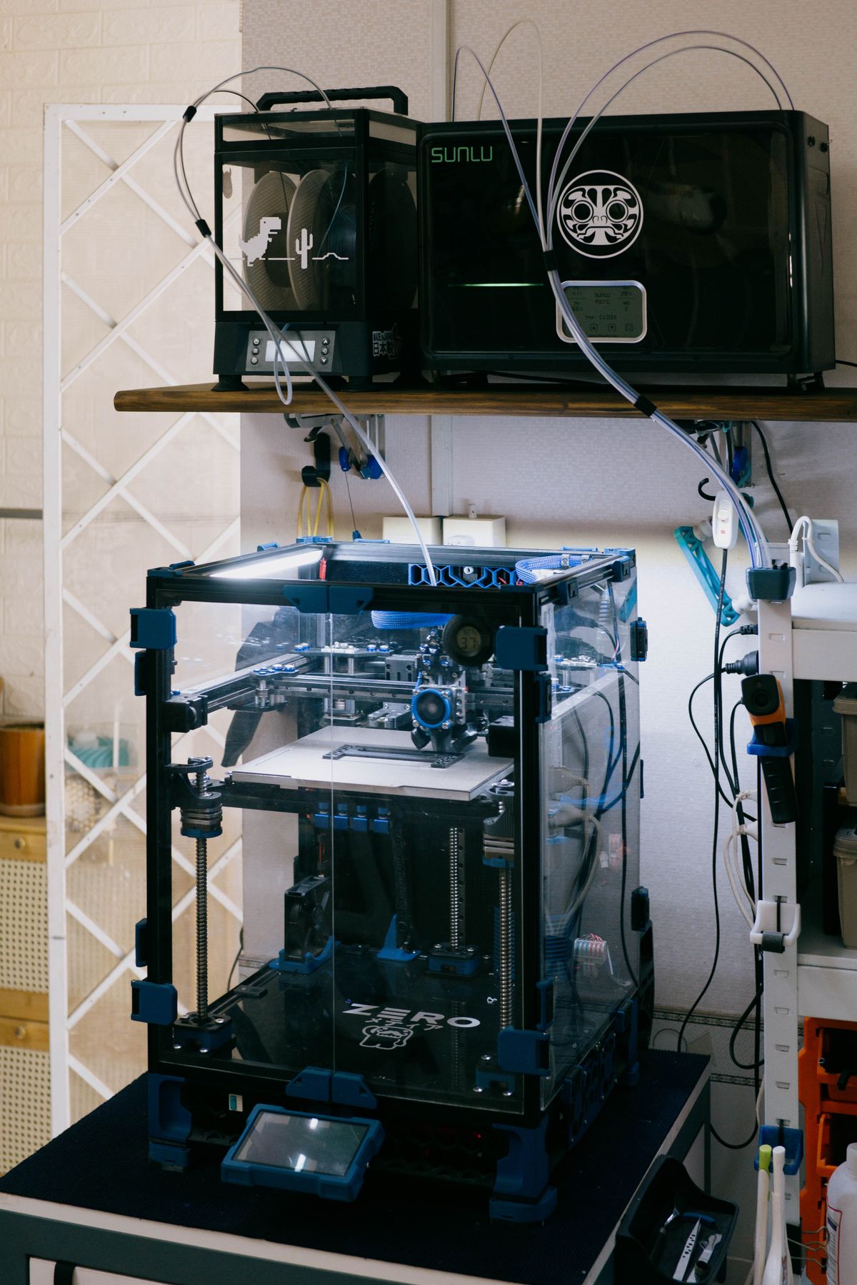 A modern 3D printer setup in a technology workshop with various tools and devices