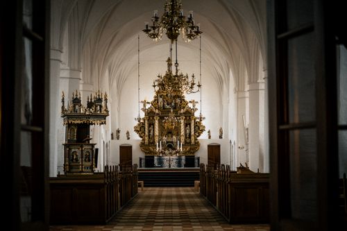 Free A breathtaking view of an ornate golden altar in a historic European church interior. Stock Photo