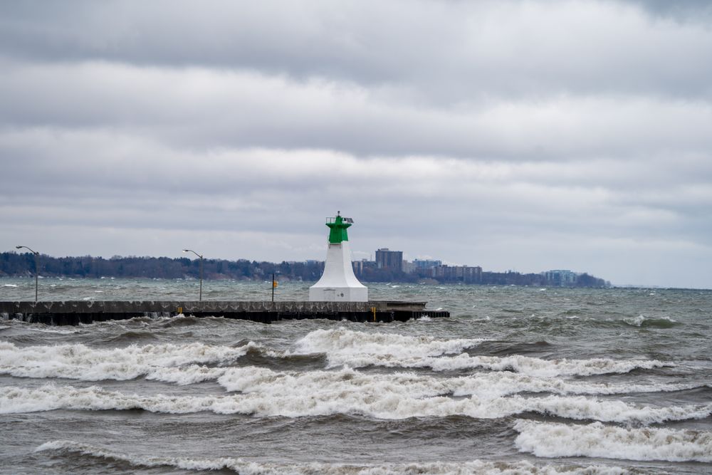 Dramatic view of Lighthouse on a stormy day with crashing waves on Lake Ontario.