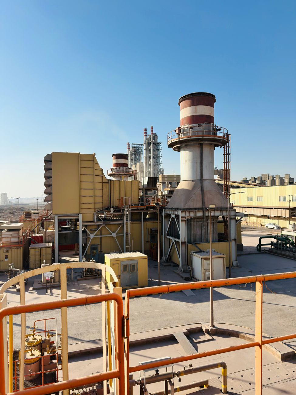 Industrial gas-turbine generator units with distinctive red-and-white striped exhaust stacks, similar to the natural-gas turbines Boom Supersonic is adapting for AI data-center power.