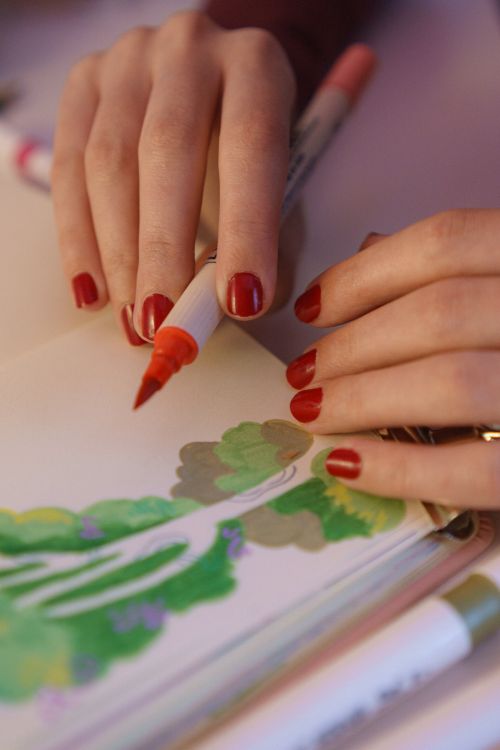 Free Artistic close-up of hands drawing with markers on paper, featuring vibrant colors and creativity. Stock Photo