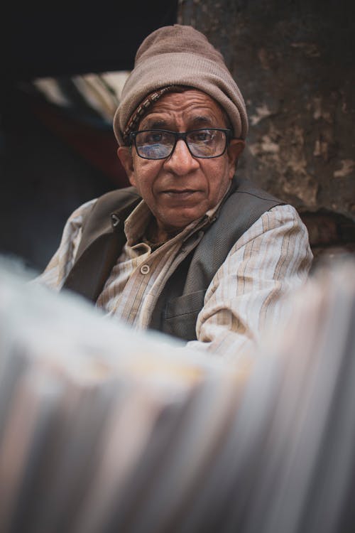 Man in Brown and White Plaid Button Up Shirt Wearing Black Framed Eyeglasses