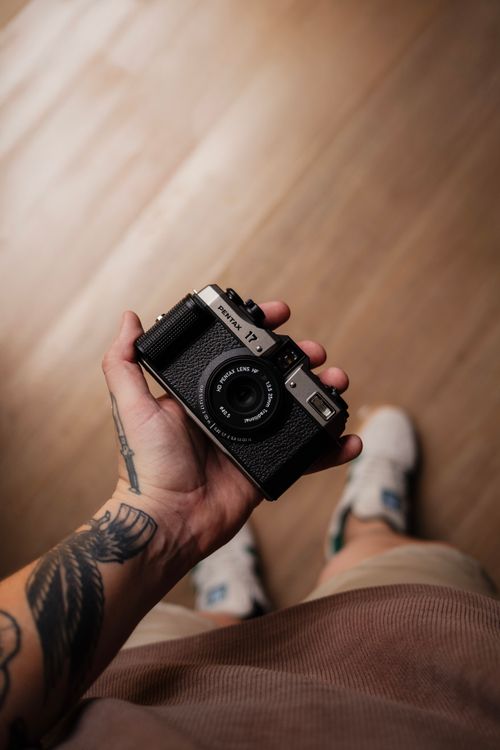 Free A person holds a vintage Pentax 17 film camera, showcasing analog photography charm. Stock Photo