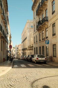 Discover a picturesque street in Lisbon, Portugal, showcasing classic architecture and a serene urban setting.
