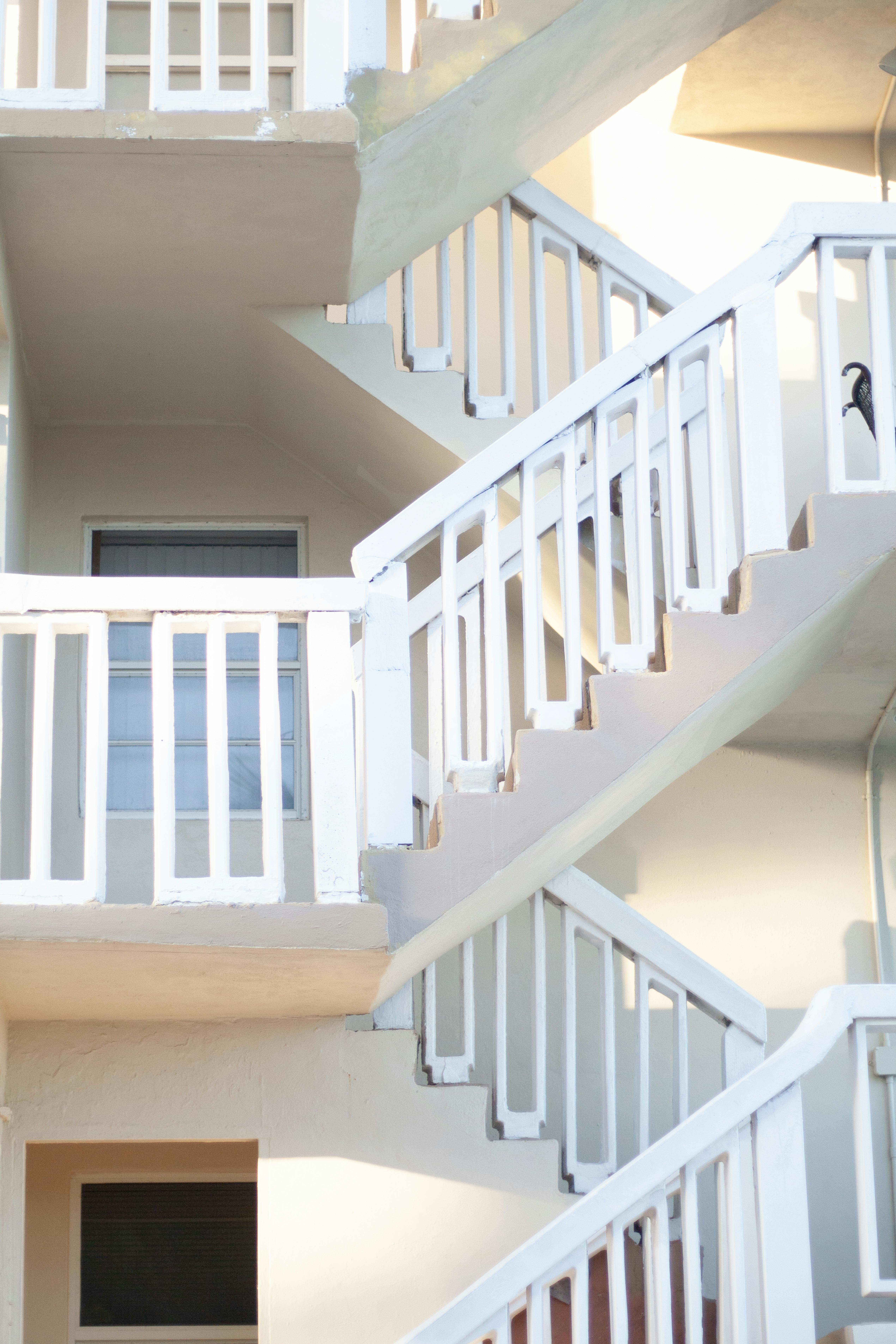 Gratis Lyst utendørsbilde av en moderne geometrisk trapp med hvite rekkverk og levende belysning. Arkivbilde