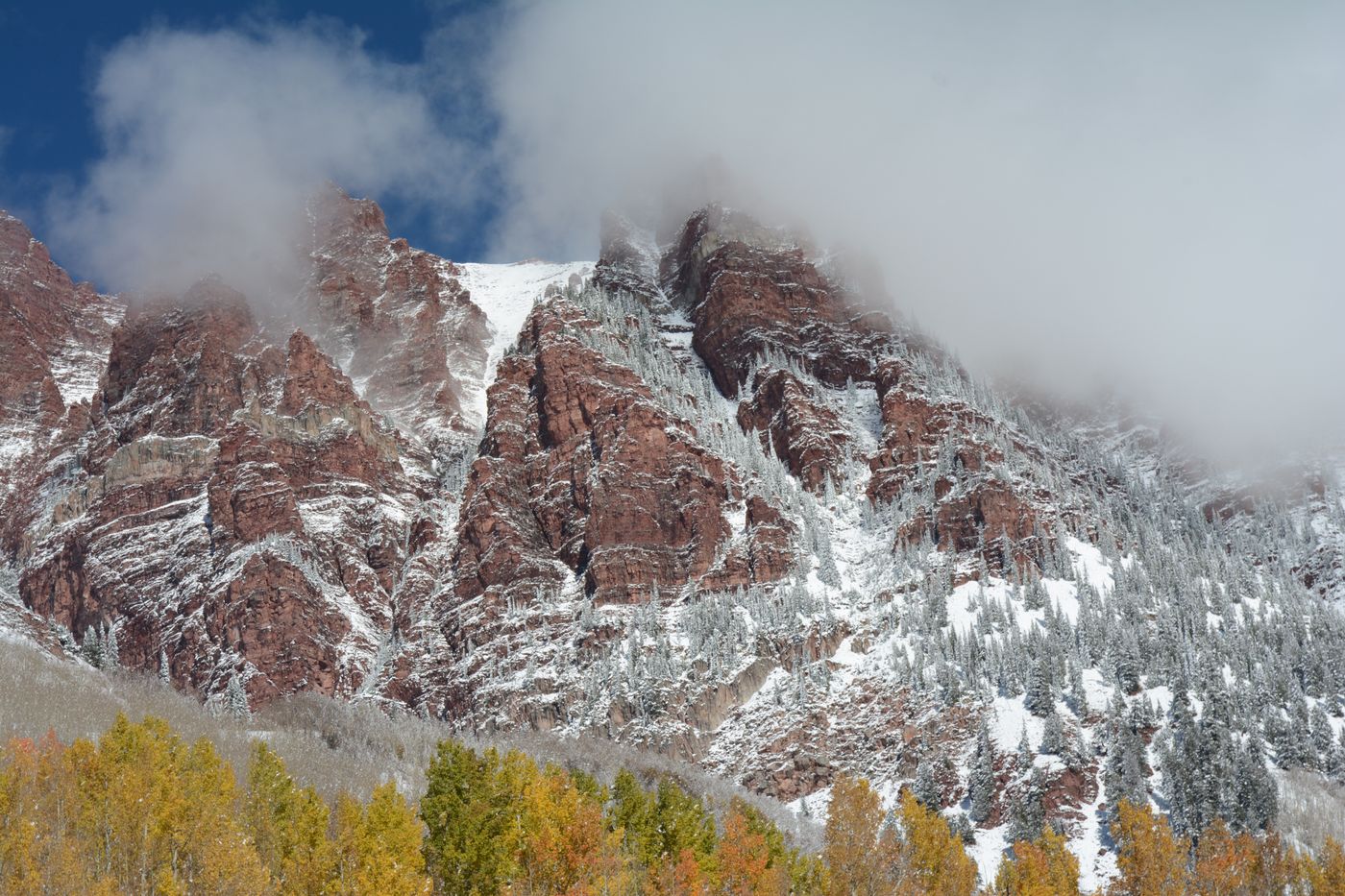 Snow-dusted Rocky Mountain peaks above autumn foliage at Aspen, Colorado