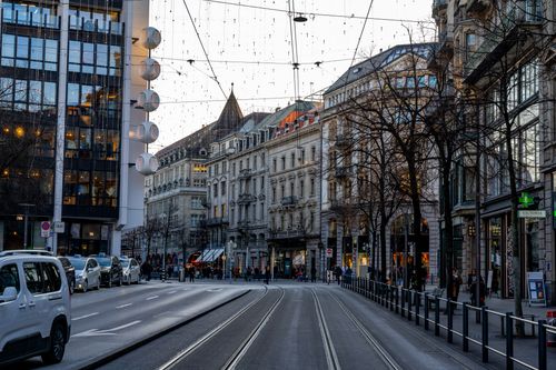 Free Street view of Bahnhofstrasse, Zürich during twilight with city lights and architectural buildings. Stock Photo