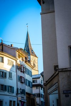 View of St. Peter's Church Tower among traditional buildings in Zürich's Old Town.